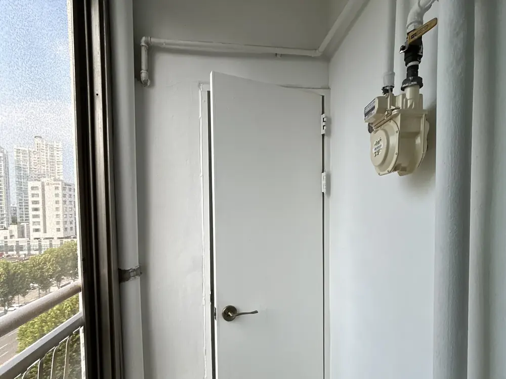 베란다 벽 균열 보수 작업 후 — 가스 미터와 문이 있는 벽면이 정리된 상태(같은 현장 촬영)