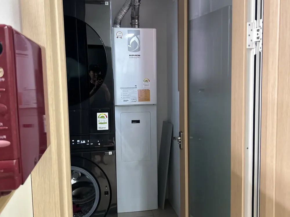 베란다 보일러실 리모델링 작업 전 — 보일러와 세탁·건조기가 나란히 놓인 보일러실 내부